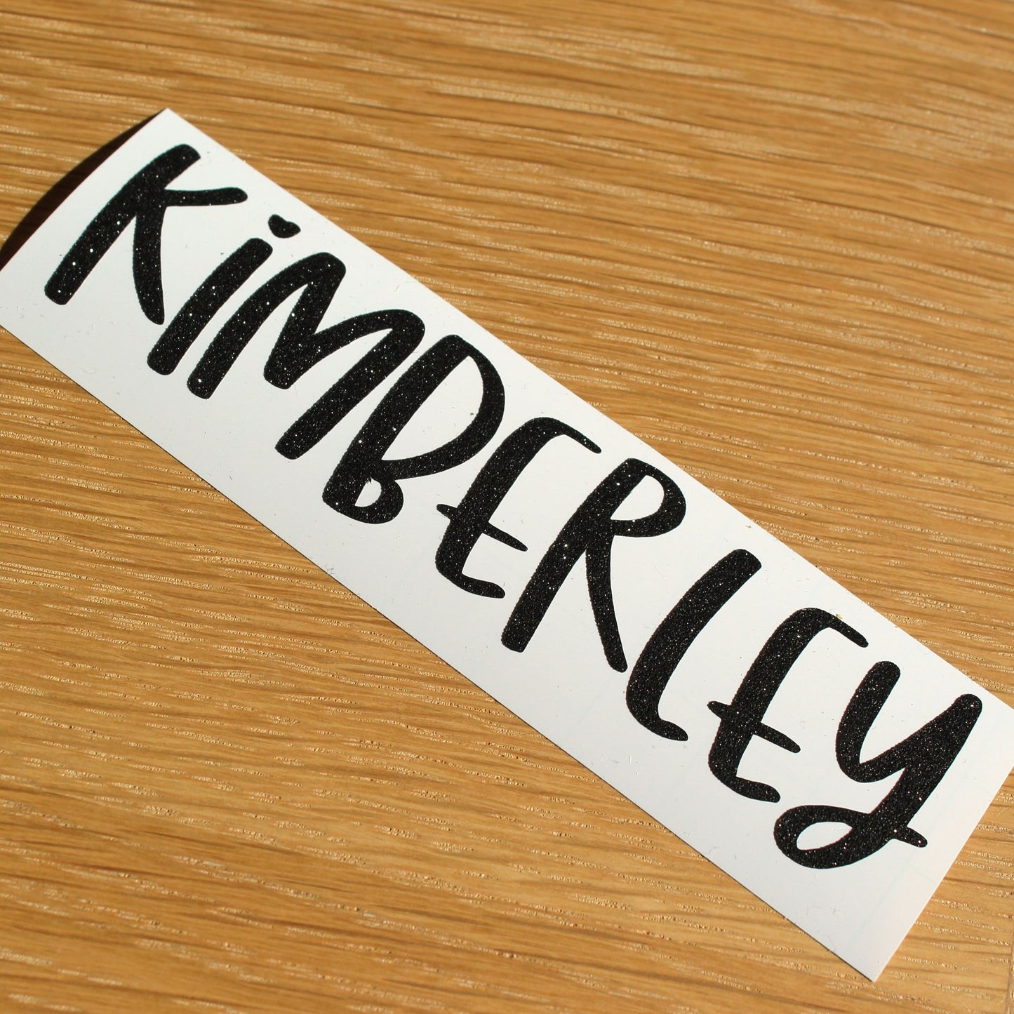 Name in 'fun' text. Black shimmer lettering.
