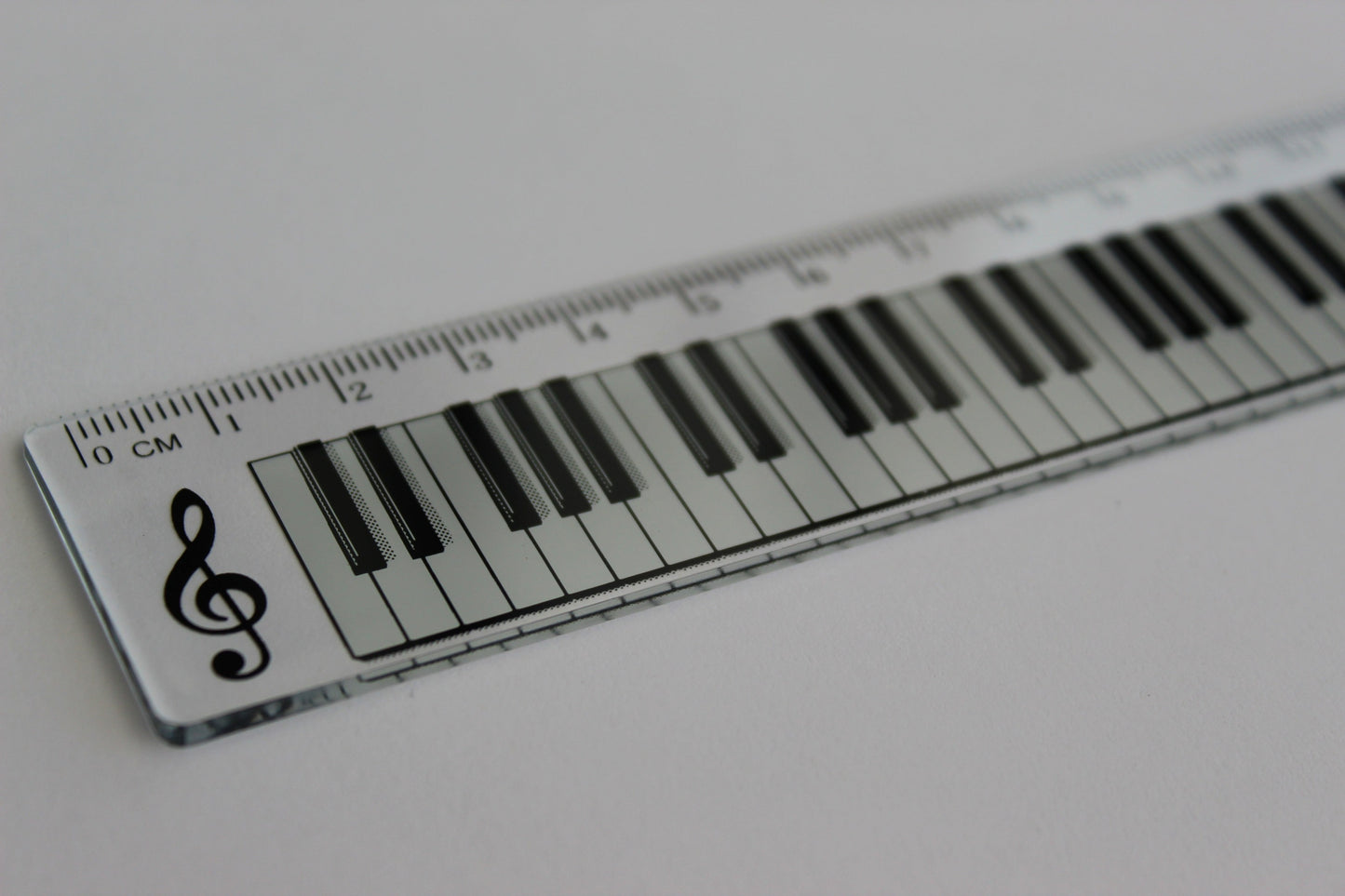 Clear ruler with a piano keyboard and treble clef design.