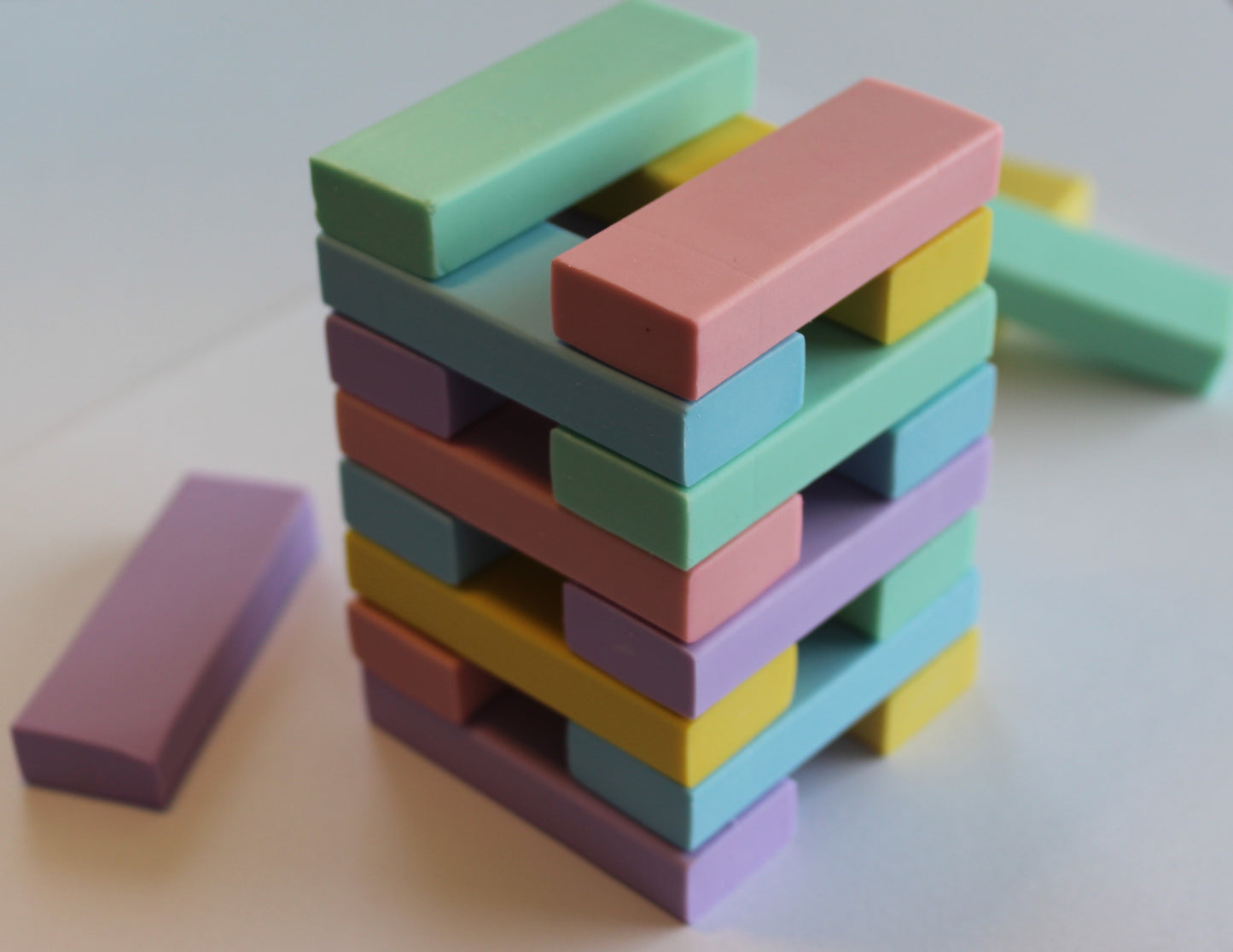 pastel green, blue, pink yellow and purple rubbers in a jenga design