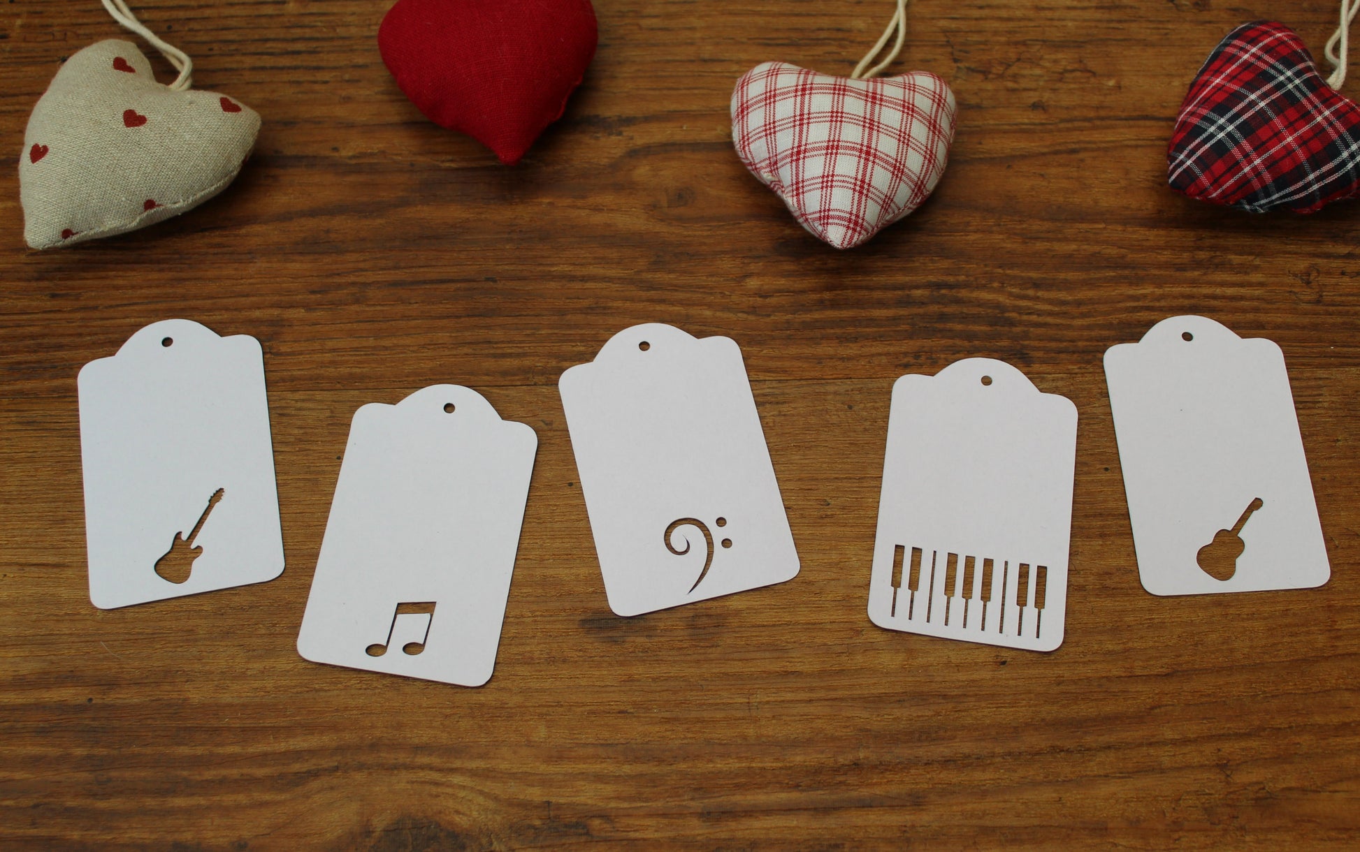 White tags displayed on a wooden background with red hearts around.