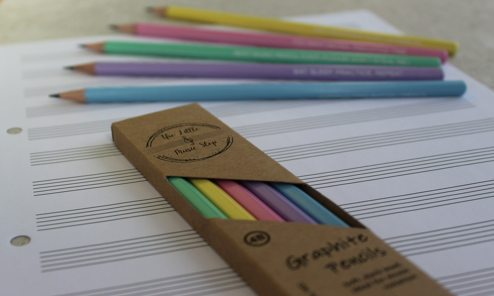 A pack of pencils in a box. Faded out image of loose pencils in the background.