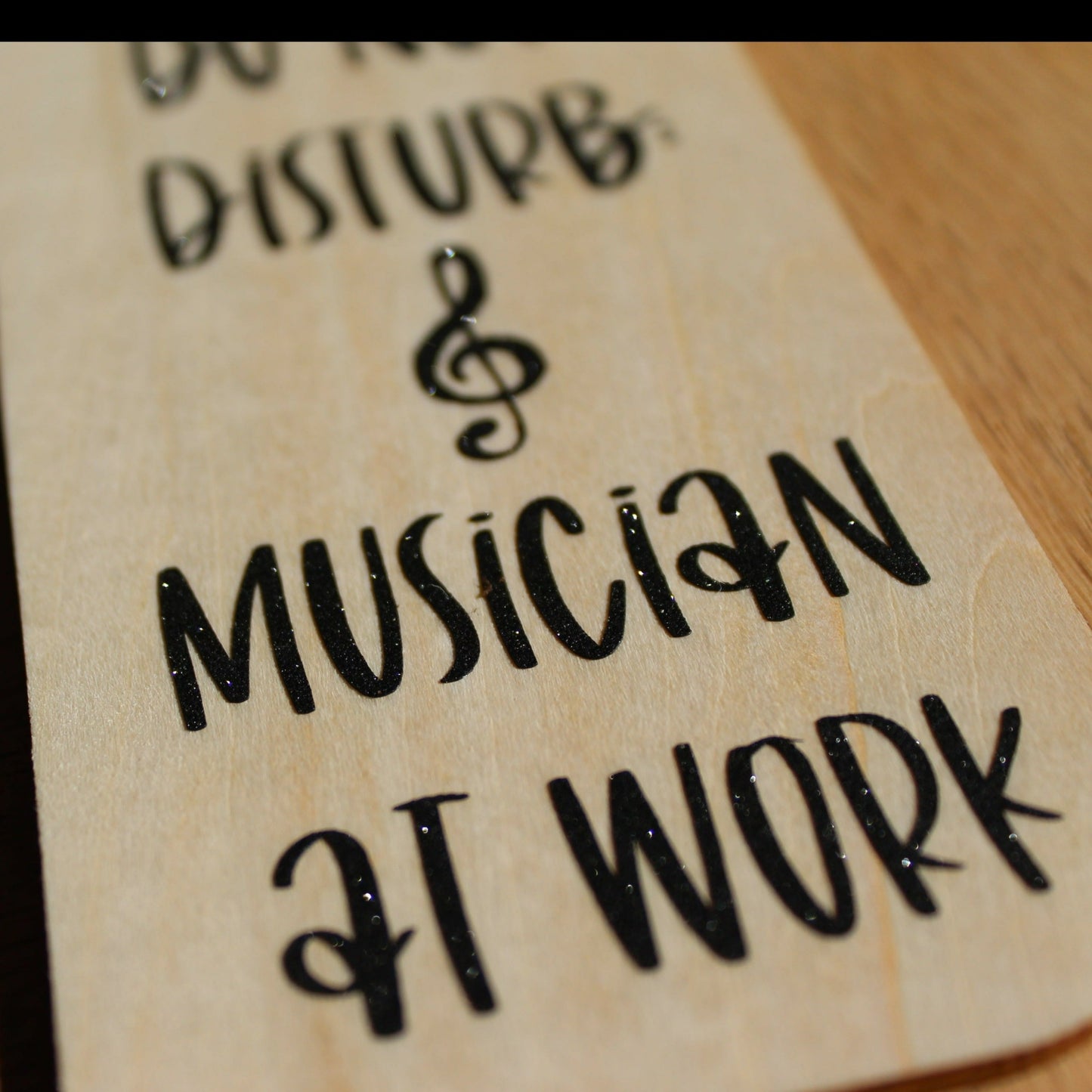 Close up of black shimmer text on the door hanger