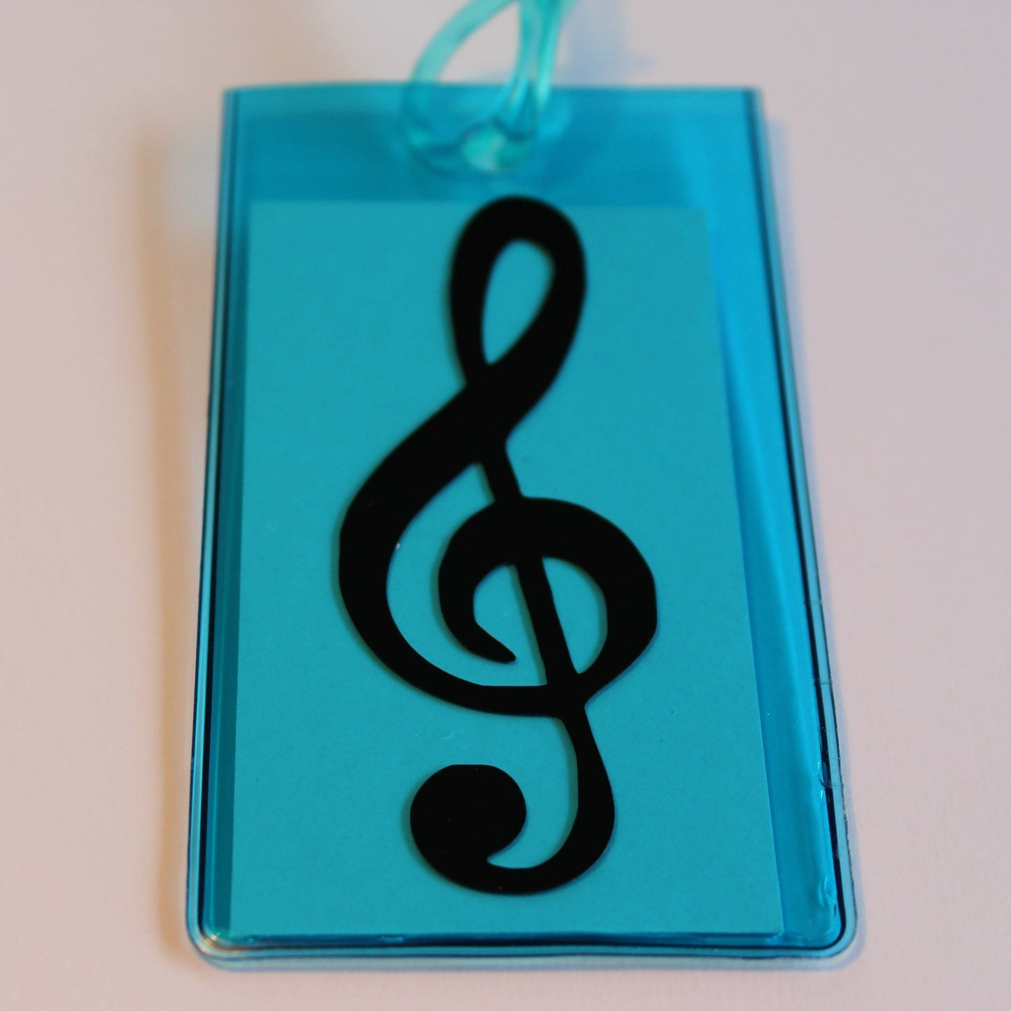 Blue instrument tag with black treble clef.