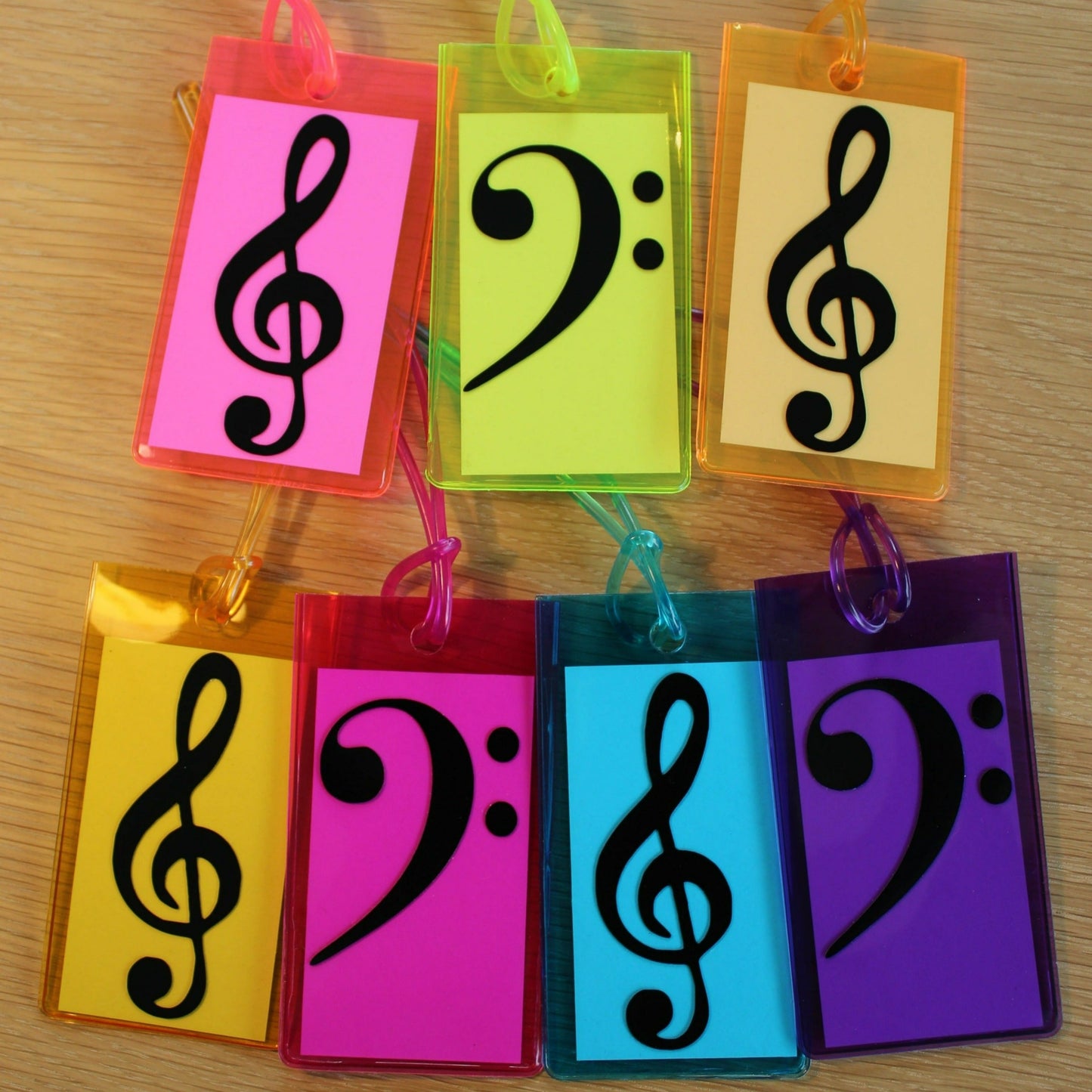 7 instrument tags in various bright colours. All have either a treble or bass clef on the front in black.