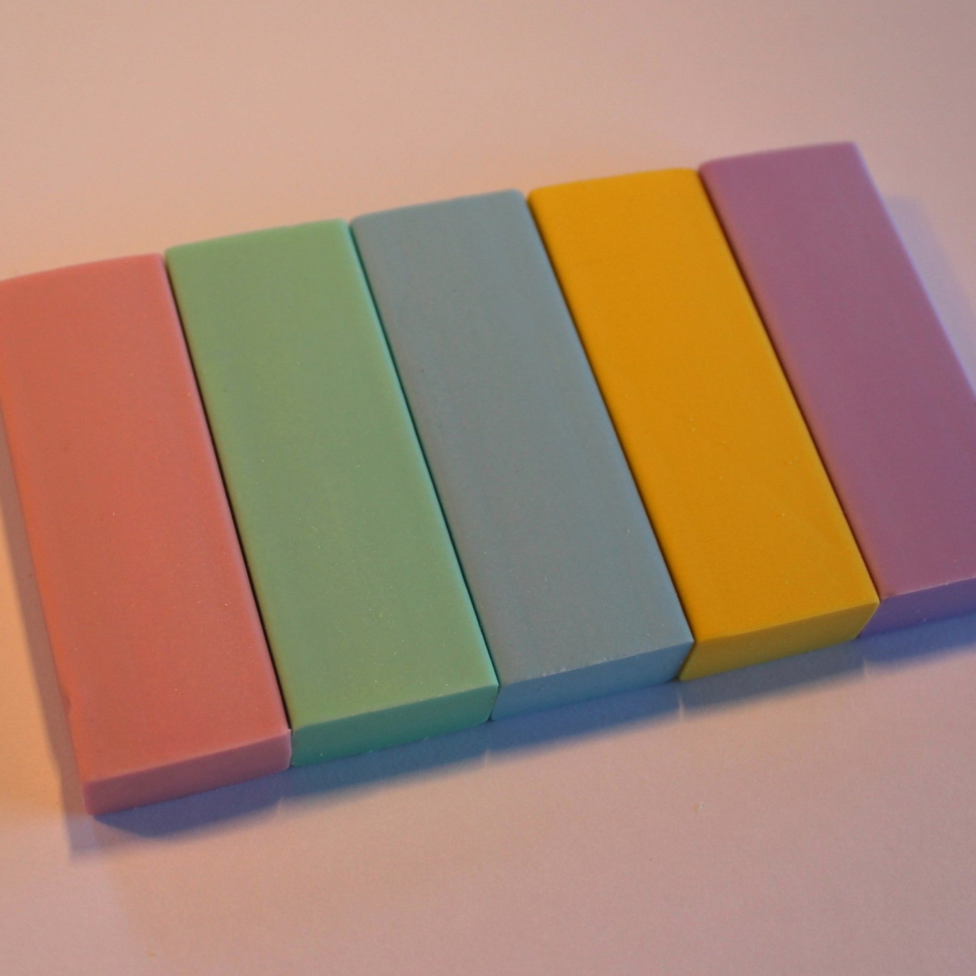 A pack of pastel green, blue, pink yellow and purple rubbers.