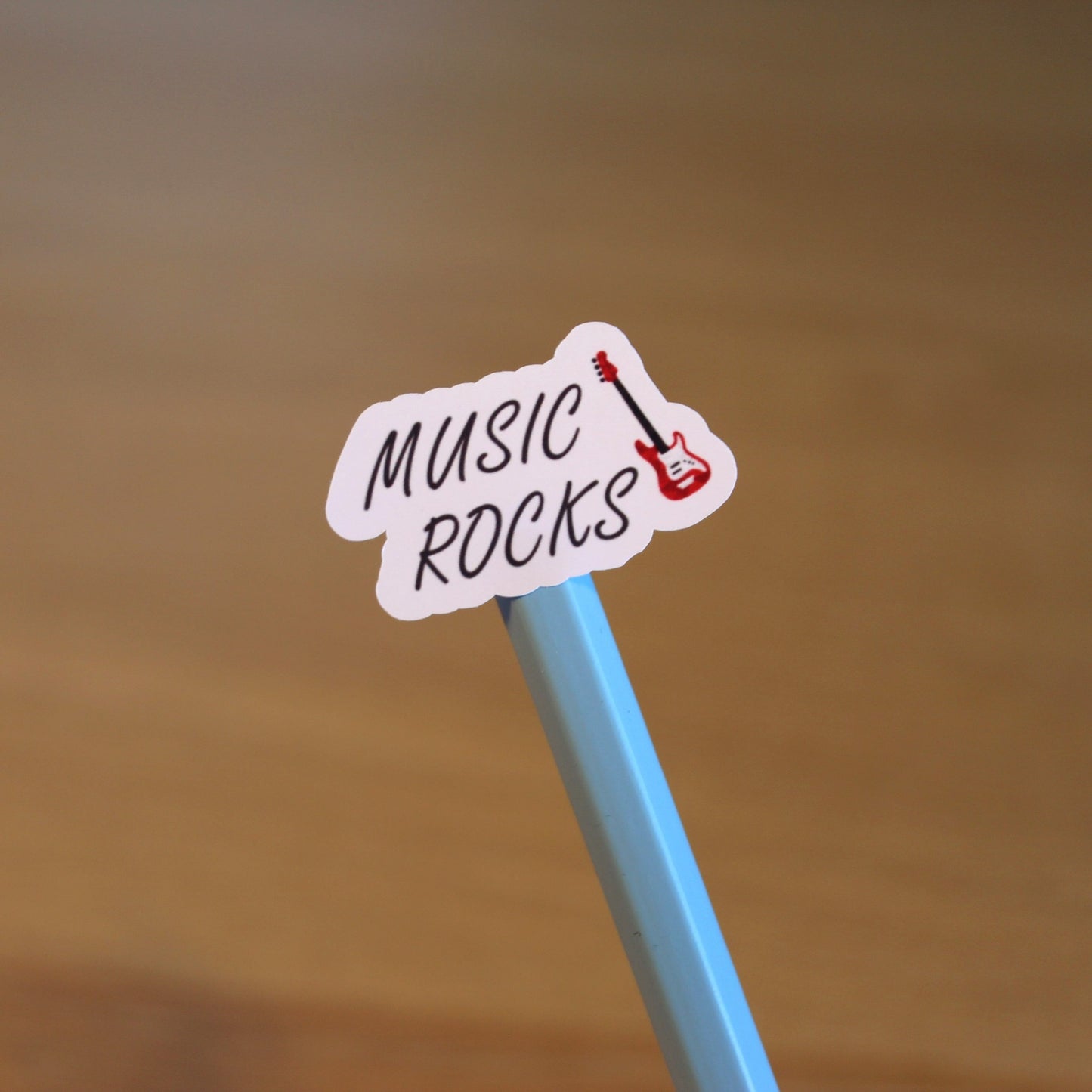 'Music Rocks' sticker displayed on the end of a pencil