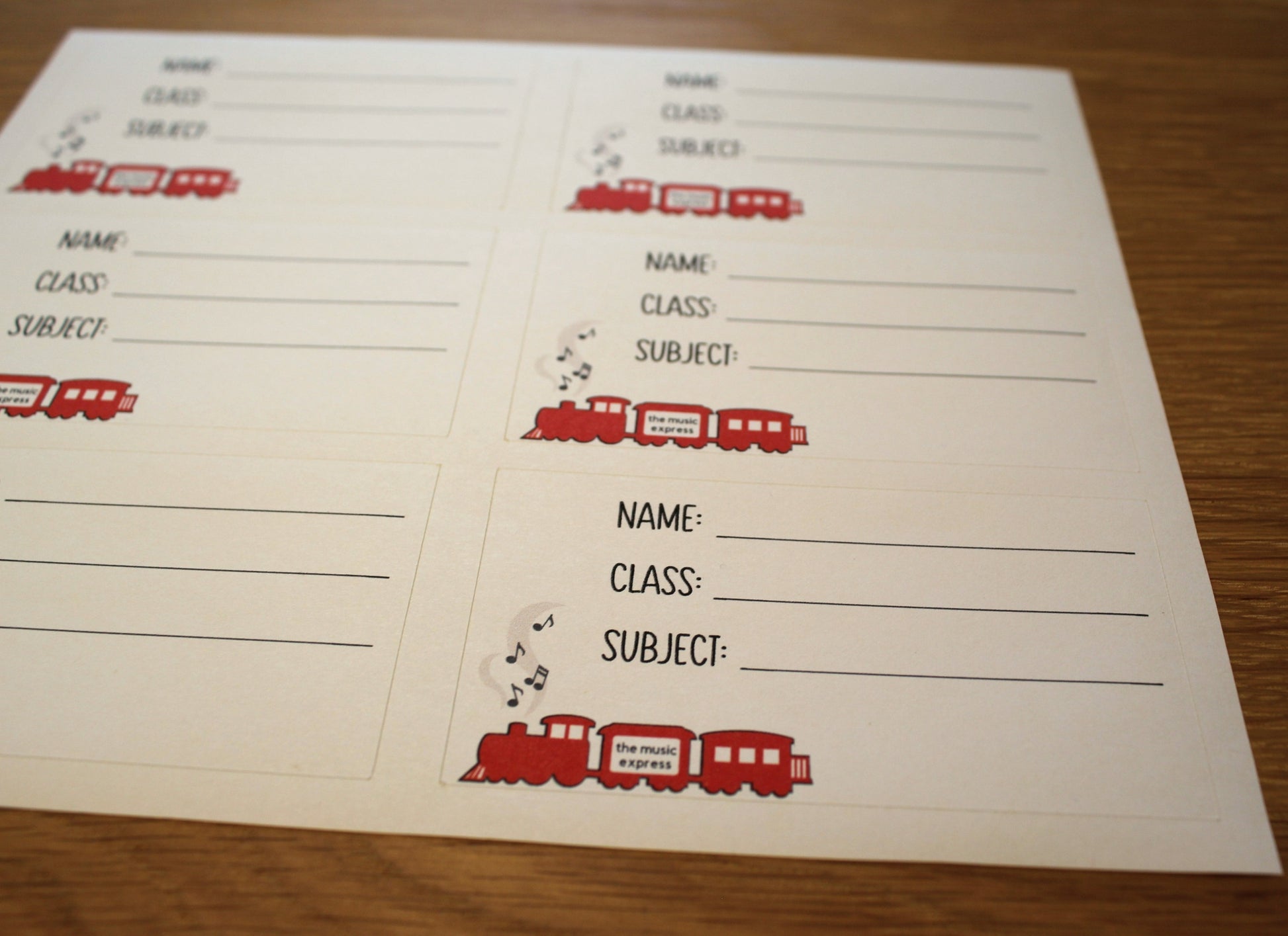 A sheet of 6 book labels with spaces to write name, class and subject. Picture of red steam train with music coming out of the funnel.